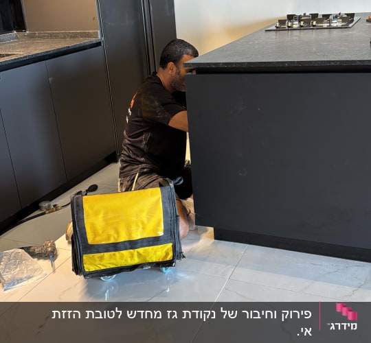 אדם עובד על התקנת מטבח עם כלי עבודה